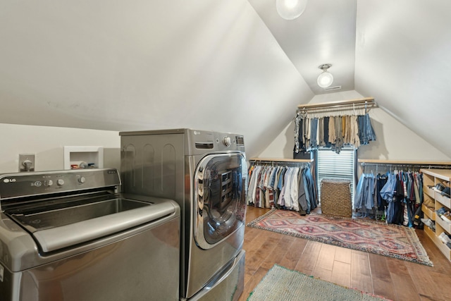 clothes washing area featuring washer and clothes dryer, laundry area, and wood-type flooring