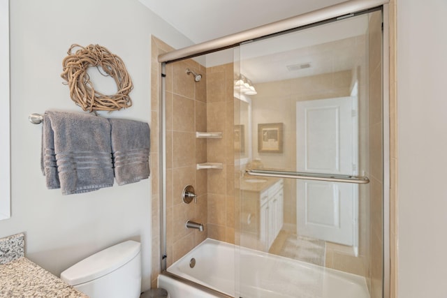 full bathroom with vanity, toilet, visible vents, and enclosed tub / shower combo