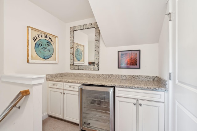 bar featuring wine cooler, light carpet, and a dry bar