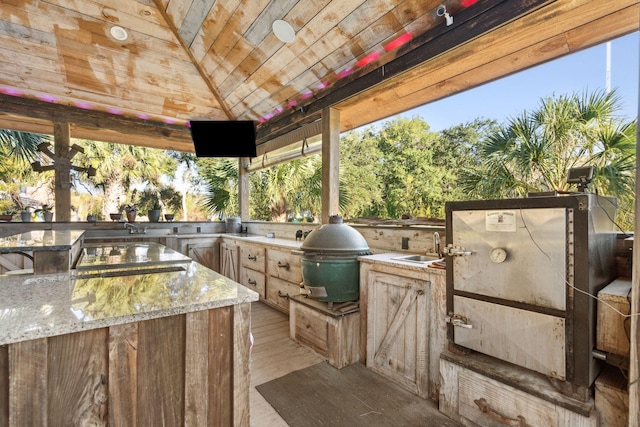 view of patio featuring a gazebo, exterior kitchen, area for grilling, and a sink