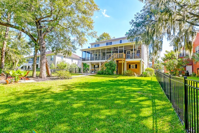 rear view of property with a yard and a sunroom