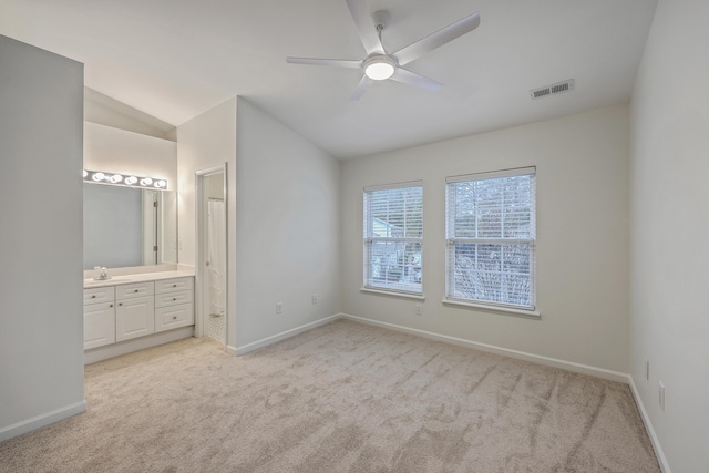 unfurnished bedroom with ceiling fan, light colored carpet, vaulted ceiling, and connected bathroom