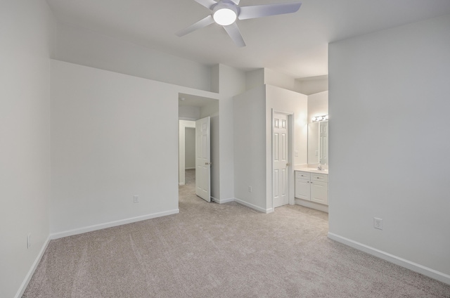 unfurnished bedroom with ensuite bath, light colored carpet, and ceiling fan