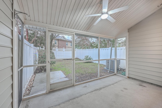 unfurnished sunroom with ceiling fan, a healthy amount of sunlight, and vaulted ceiling