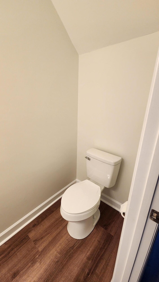 bathroom with toilet, lofted ceiling, and hardwood / wood-style floors