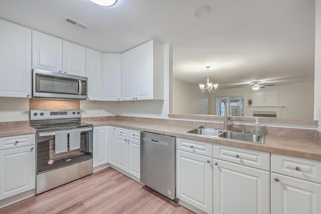 kitchen featuring ceiling fan with notable chandelier, sink, white cabinets, and stainless steel appliances