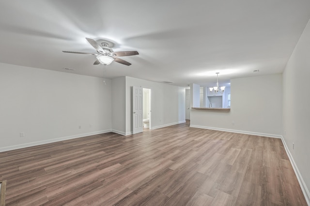 interior space with ceiling fan with notable chandelier and wood-type flooring