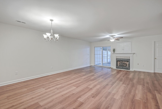 unfurnished living room featuring light wood-type flooring and ceiling fan with notable chandelier