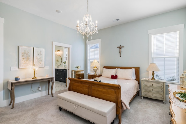 carpeted bedroom with ensuite bathroom and a chandelier