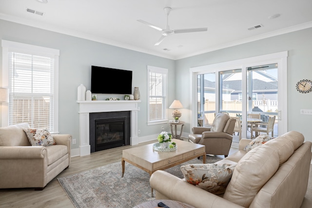 living room featuring crown molding, light hardwood / wood-style floors, and ceiling fan