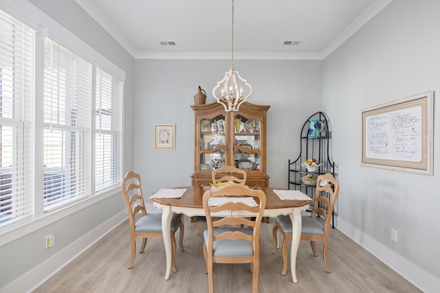 dining area featuring a notable chandelier, crown molding, and light wood-type flooring