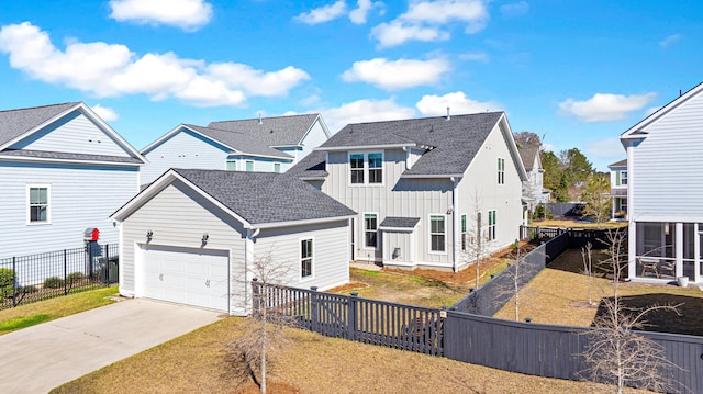 view of front of home featuring a fenced backyard, a garage, concrete driveway, roof with shingles, and board and batten siding