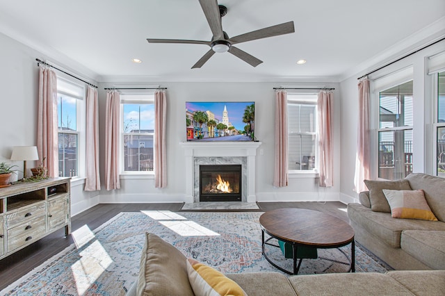 living area featuring baseboards, a premium fireplace, recessed lighting, and crown molding