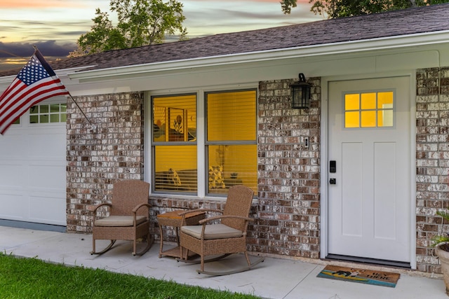 1990 Butternut St, Charleston, SC 29414 - doorway to property featuring brick siding, covered porch, and a shingled roof