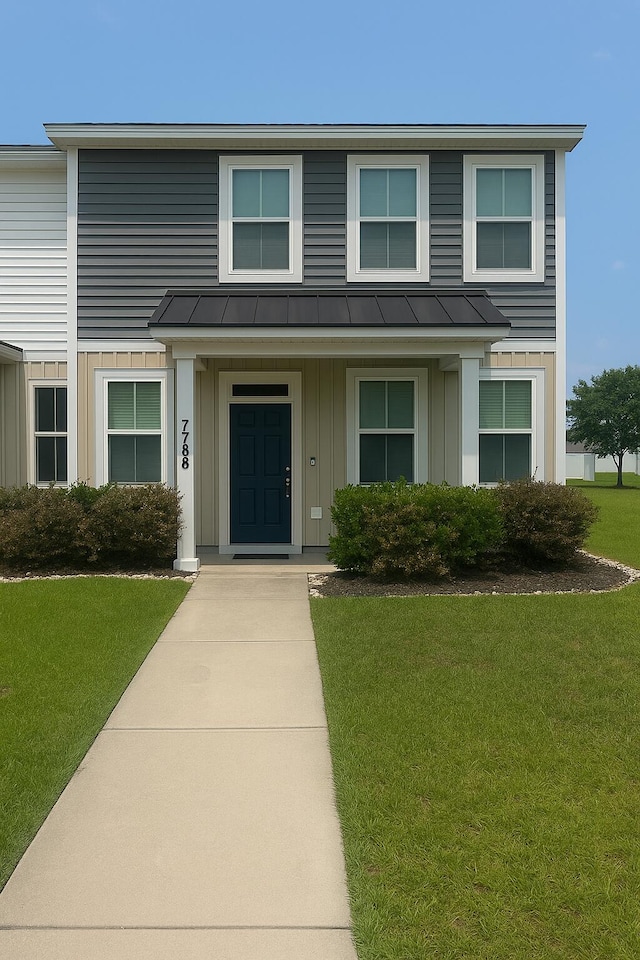 7788 Montview Rd, North Charleston, SC 29418 - view of front of house with board and batten siding, a standing seam roof, and a front lawn