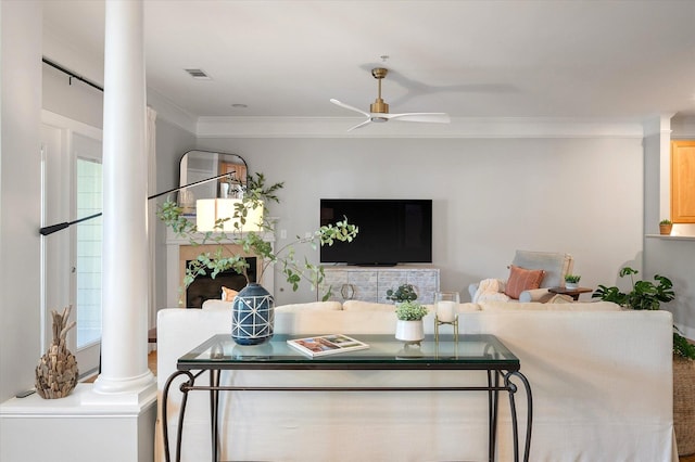 living room with crown molding, ceiling fan, decorative columns, and visible vents