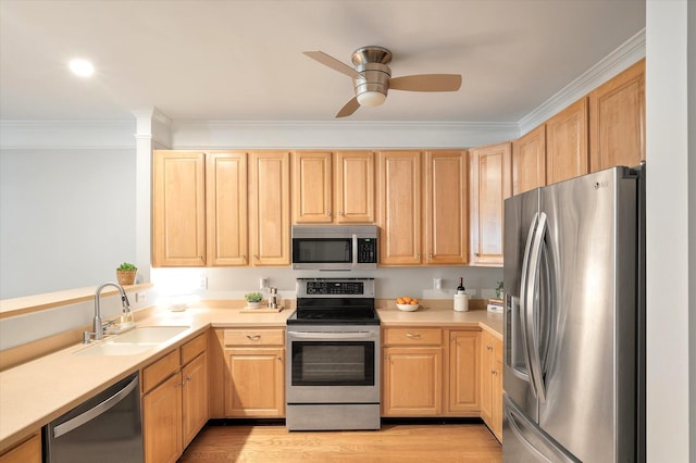 kitchen featuring light brown cabinetry, appliances with stainless steel finishes, a sink, and light countertops