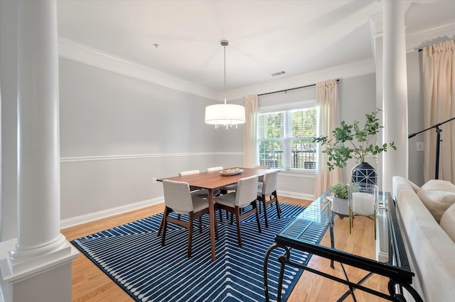 dining room featuring baseboards, ornate columns, wood finished floors, and visible vents