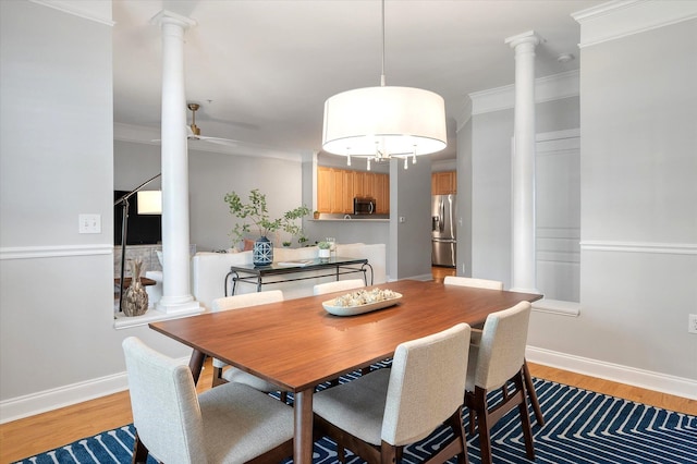 dining area featuring ornate columns, light wood finished floors, and ceiling fan