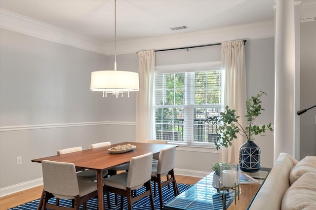 dining area with baseboards, ornamental molding, and light wood finished floors