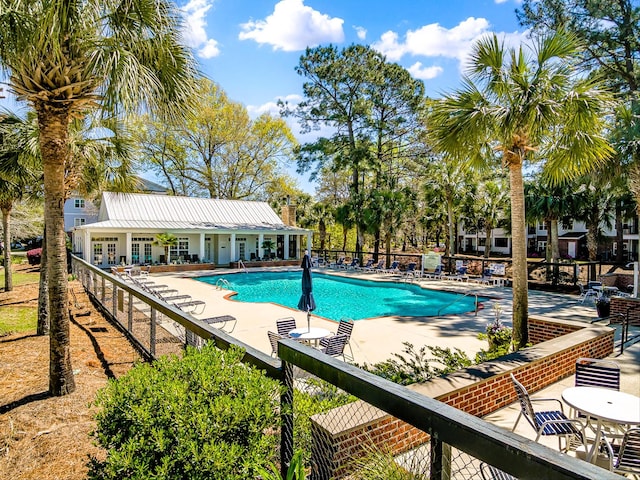 pool with a patio and fence