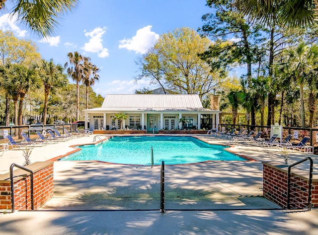 pool featuring a patio area, fence, and french doors