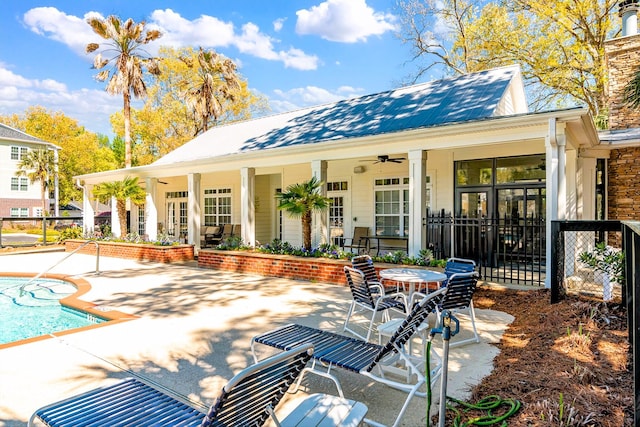 back of property featuring a patio, a ceiling fan, fence, and metal roof