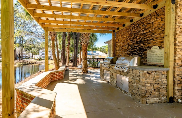 view of patio / terrace with an outdoor kitchen, a water view, and area for grilling
