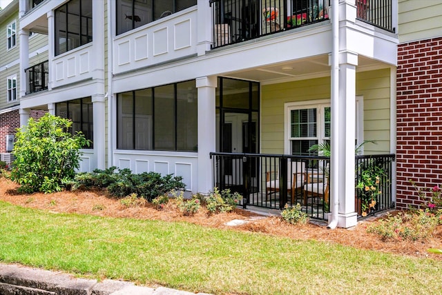 doorway to property featuring brick siding and a yard
