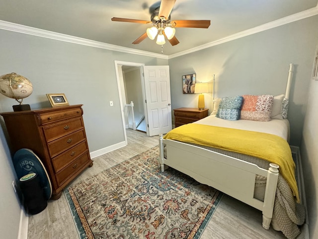 bedroom featuring light wood-type flooring, baseboards, ornamental molding, and a ceiling fan