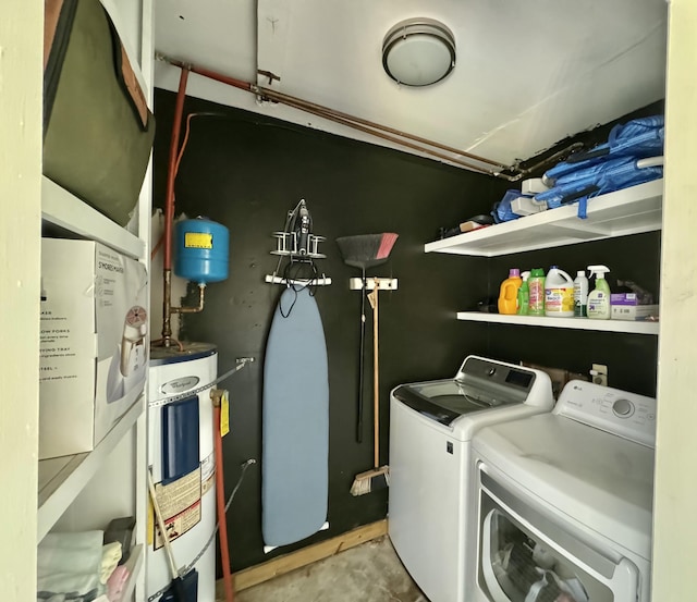 laundry area featuring electric water heater, laundry area, and washing machine and clothes dryer