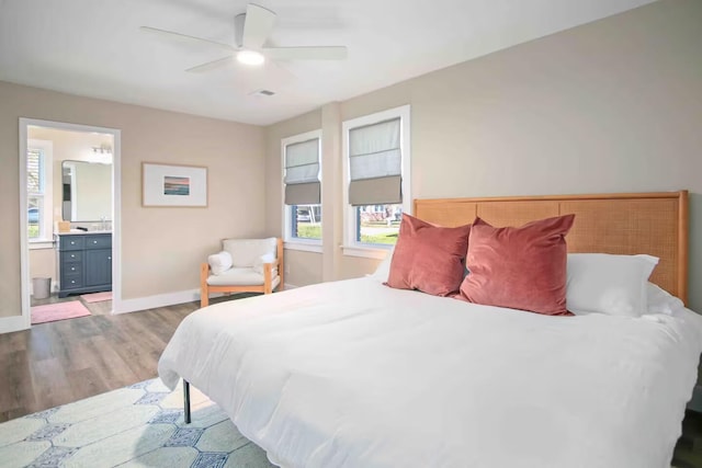 bedroom featuring sink, light wood-type flooring, connected bathroom, and ceiling fan