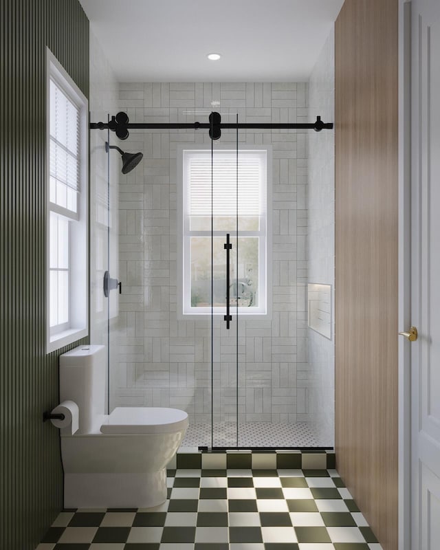 bathroom featuring a shower with door and toilet