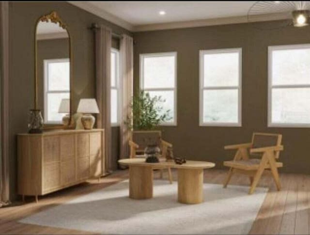 living area with crown molding and light hardwood / wood-style flooring