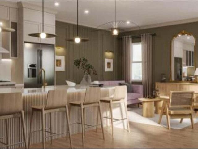 kitchen featuring pendant lighting, stainless steel fridge, white cabinetry, light hardwood / wood-style floors, and a kitchen bar