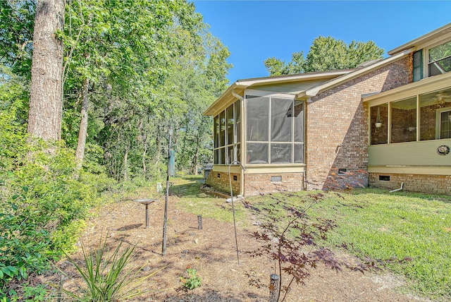 view of home's exterior with a sunroom, crawl space, and a yard