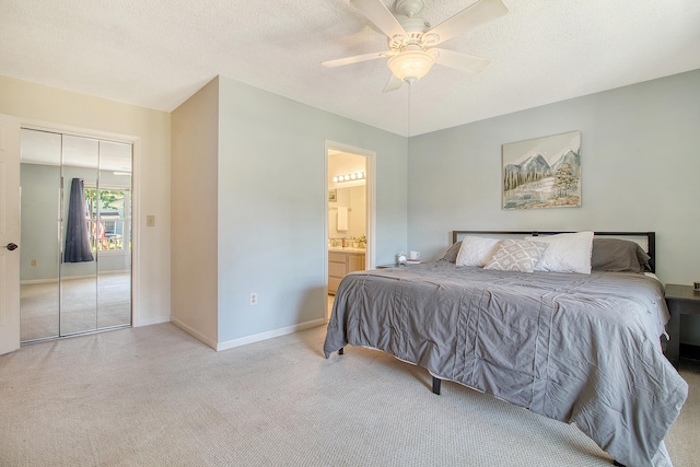 bedroom featuring carpet flooring, baseboards, a ceiling fan, ensuite bathroom, and a closet