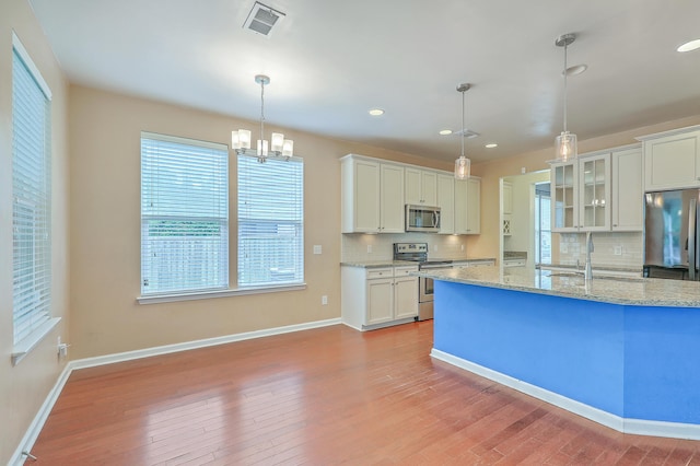 1350 Wild Goose Trl, Summerville, SC 29483 - kitchen with appliances with stainless steel finishes, decorative backsplash, a chandelier, white cabinetry, and light wood finished floors
