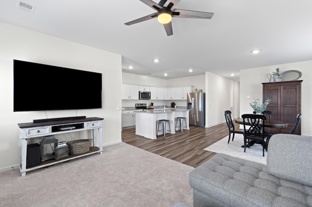 carpeted living room with ceiling fan