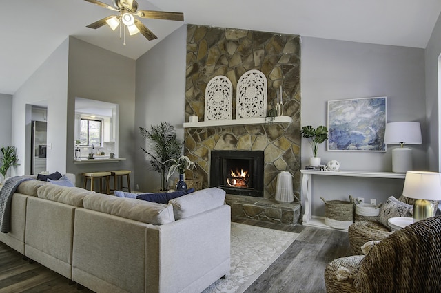 living room with lofted ceiling, ceiling fan, a fireplace, and dark wood-type flooring