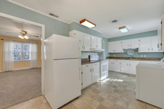 kitchen featuring sink, white cabinets, light colored carpet, white appliances, and washer and clothes dryer