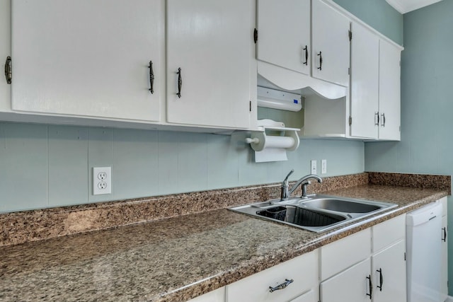 kitchen with white cabinets, white dishwasher, and sink