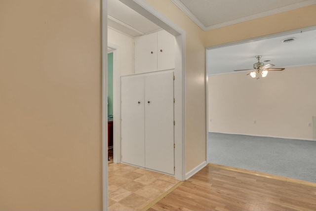 hall featuring crown molding and light carpet