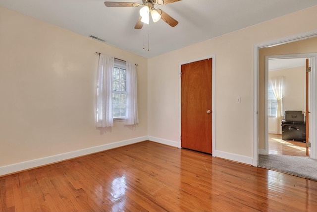 spare room with light wood-type flooring and ceiling fan