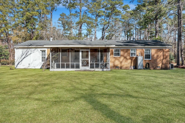 back of house featuring a sunroom, a lawn, and central AC unit