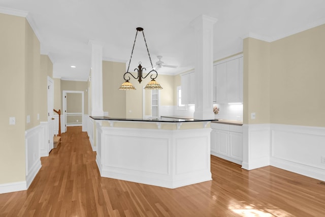 1025 Mathis Ferry Rd, Mount Pleasant, SC 29464 - kitchen featuring ornate columns, light wood-style flooring, white cabinets, crown molding, and wainscoting