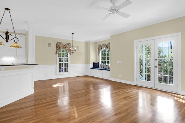 1025 Mathis Ferry Rd, Mount Pleasant, SC 29464 - unfurnished living room with a chandelier, wood finished floors, french doors, ornamental molding, and a wainscoted wall