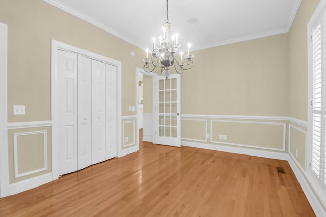 1025 Mathis Ferry Rd, Mount Pleasant, SC 29464 - unfurnished dining area with a chandelier, light wood finished floors, ornamental molding, and a wainscoted wall