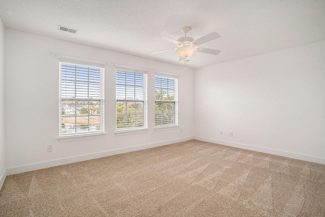 carpeted empty room with ceiling fan and a textured ceiling