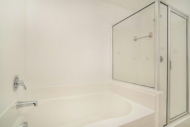 bathroom featuring shower with separate bathtub